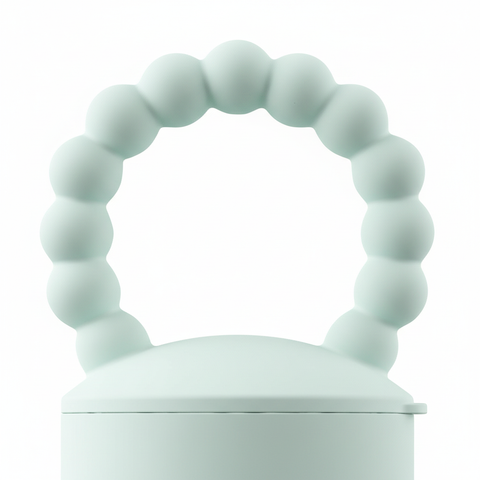 Close-up of mint green silicone beaded ring handle on BPA-free baby food feeder teether, white background