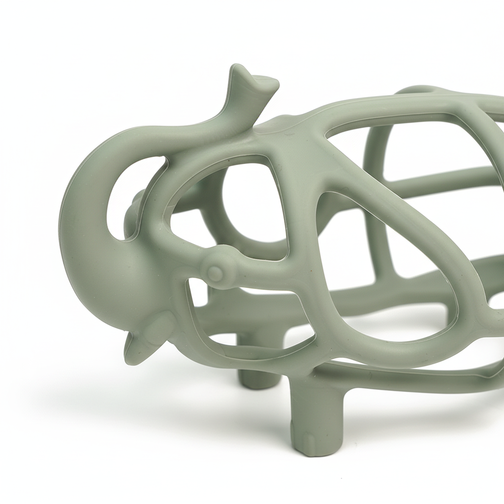 Close-up of sage green silicone ribs and open grid on hollow elephant baby teether, white background