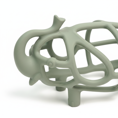 Close-up of sage green silicone ribs and open grid on hollow elephant baby teether, white background