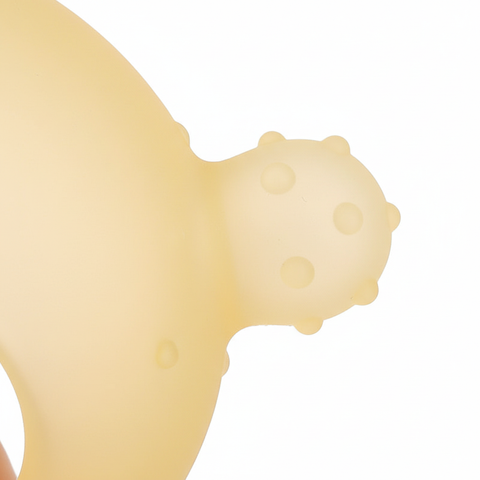 Close-up of textured bumps on BPA-free yellow silicone baby teether chew head, white background